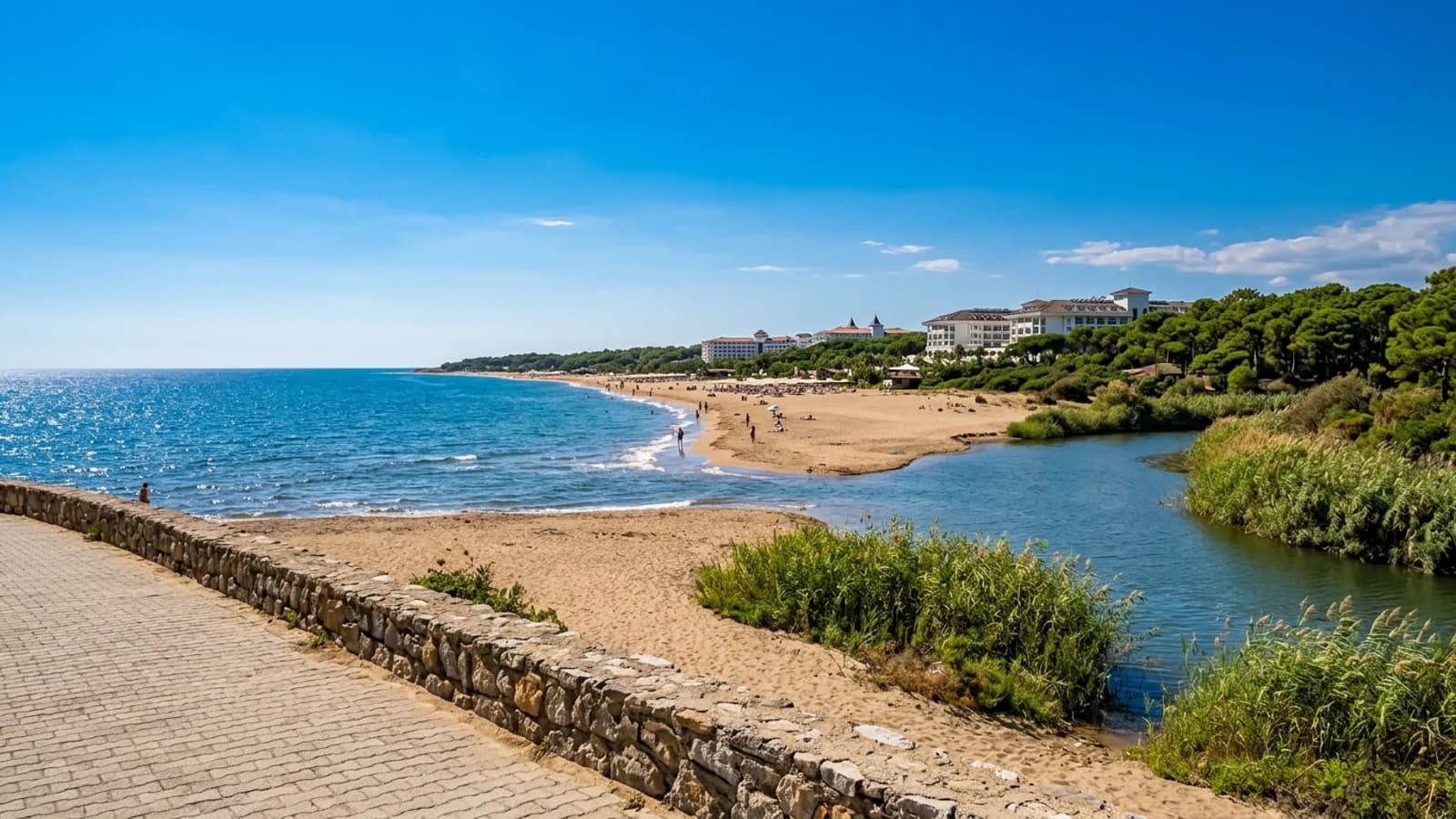 Der Fluss Köprüçay mündet bei Boğazkent an einem Sandstrand mit Schilf und fernen Resorthotels im Meer.