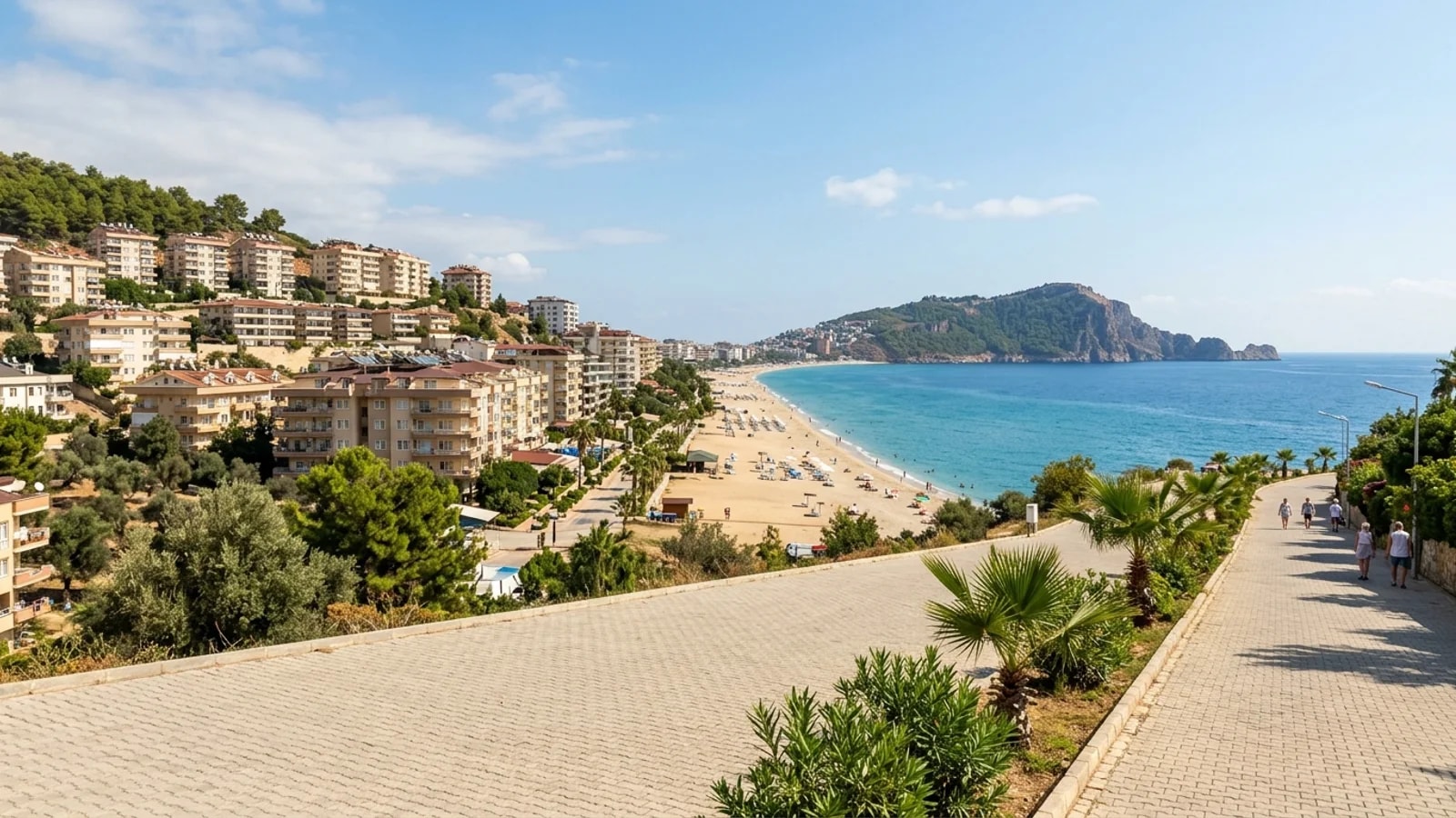 Een badplaats in Konaklı met hotels op een helling boven het zandstrand en uitzicht op Alanya.