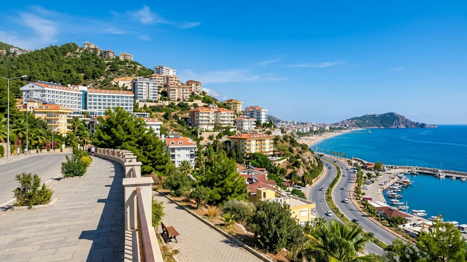 Cikcilli'nin yeşil yamaçlarında yükselen modern apartmanlar ve oteller, geniş bir deniz manzarasına bakmaktadır.