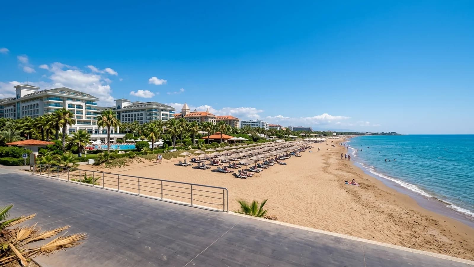 Kundu beach resort near Antalya Wide sandy beach of Kundu with resort hotels, palm gardens, sun loungers and a flat turquoise sea.