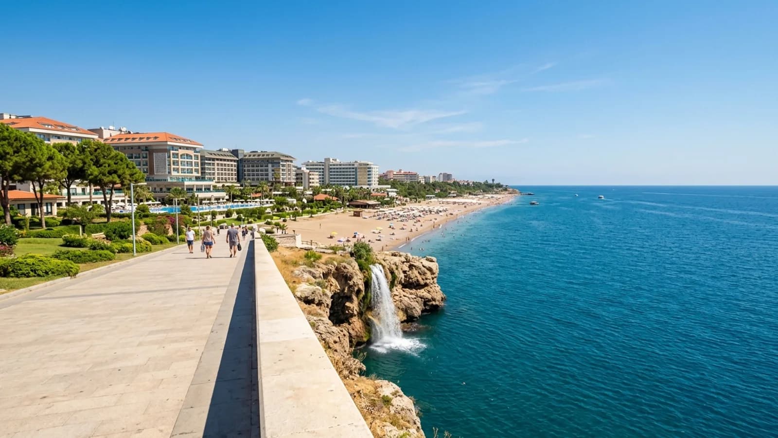 Lara-strand en waterval bij Antalya Zandstrand van Lara met hotels en een witte waterval die van kliffen in de blauwe zee stort.