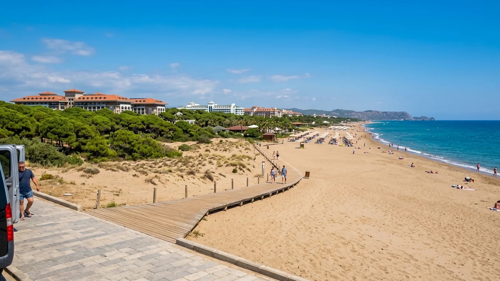 Kadriye beach resort near Antalya A broad sandy beach at Kadriye with a pine forest, resort hotels, and a wooden boardwalk.