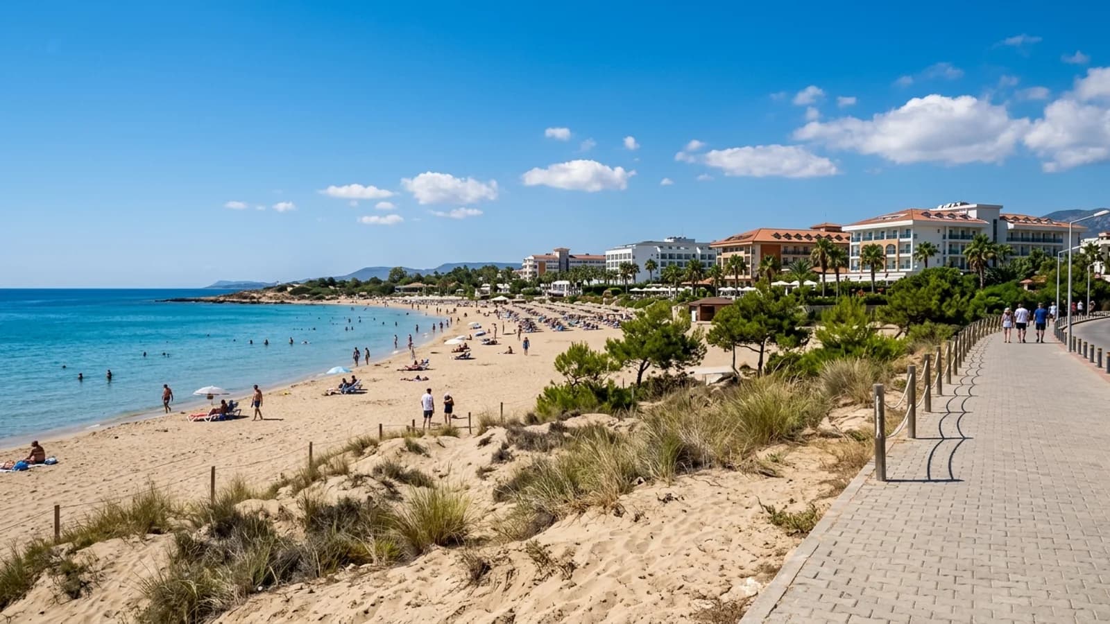 Sandstrand und Hotels in Evrenseki Breiter Sandstrand in Evrenseki mit Resorthotels hinter niedrigen Dünen und ruhigem, flachem Wasser.