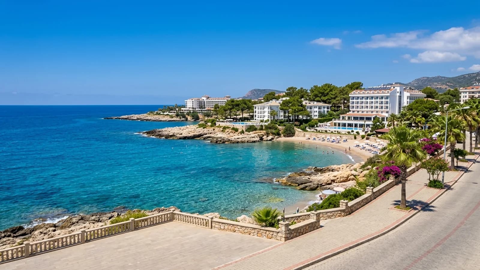 Antalya Okurcalar beldesinin eşsiz sahili Okurcalar kıyısındaki kayalık burunlar üzerinde yükselen oteller, küçük kumsallar ve berrak mavi bir deniz.