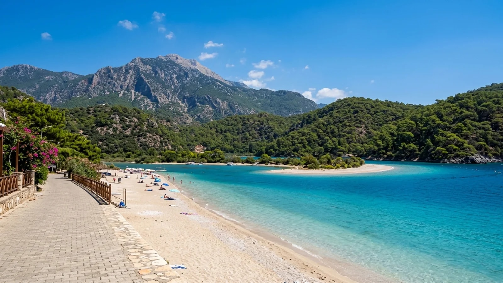 Ölüdeniz'in büyüleyici turkuaz lagünü Arkasında yüksek bir dağ ve çam kaplı tepelerin yükseldiği turkuaz renkli Ölüdeniz lagünü.