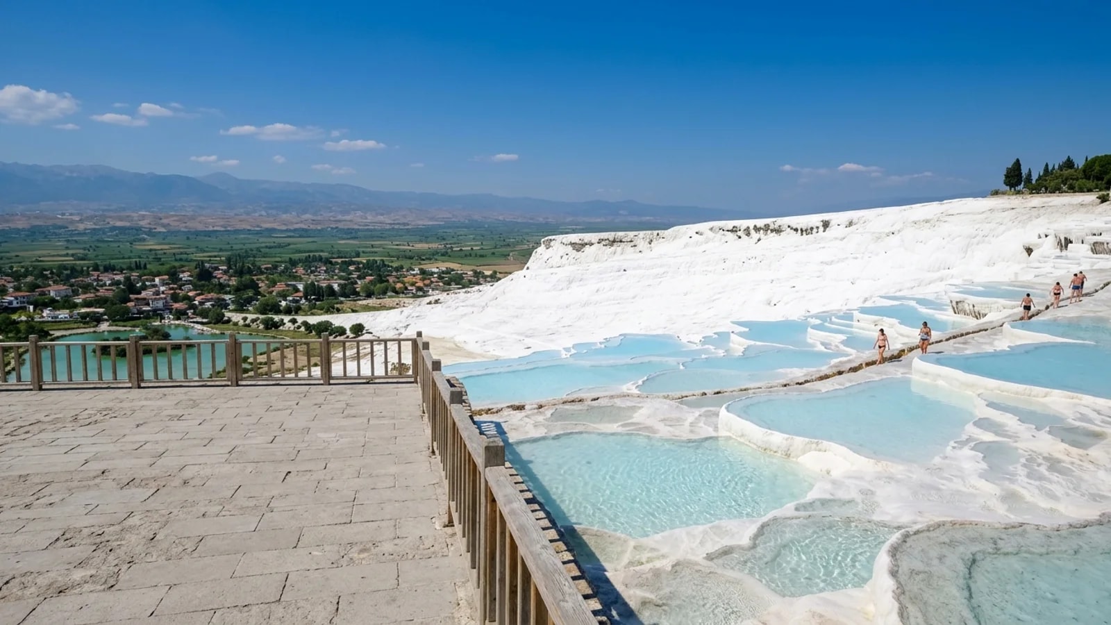 Pamukkale travertine terraces in Turkey White travertine terraces of Pamukkale filled with pale blue thermal water under the bright sun.